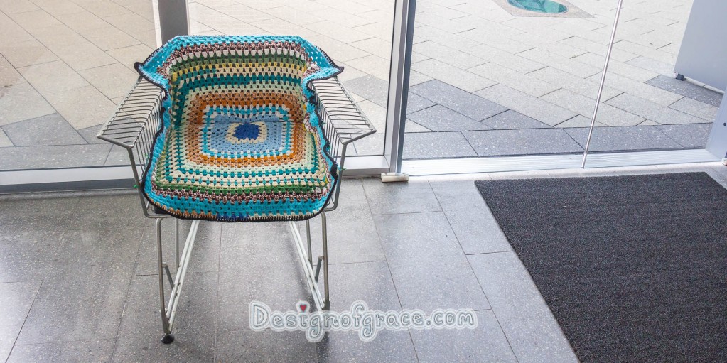 Re-cycled trolley made into a chair covered  in the top and middle section with crocheted rug