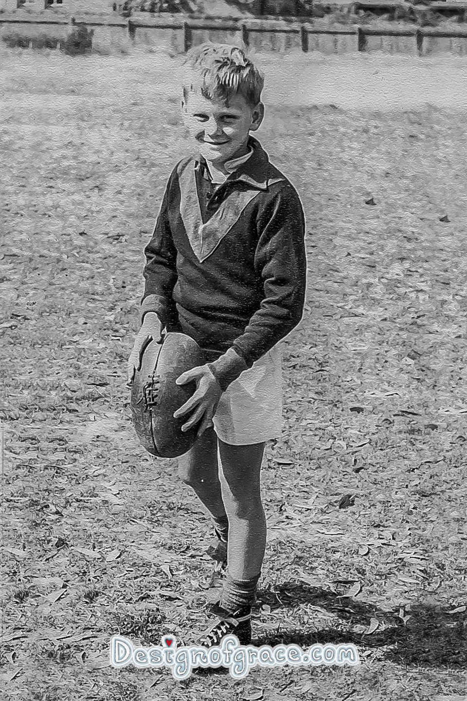 old black and white photo of a boy holding a football