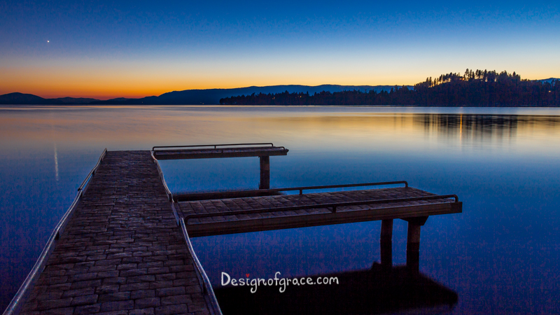 Still waters at Flathead Lake Jetty at sunset with orange and blue colours