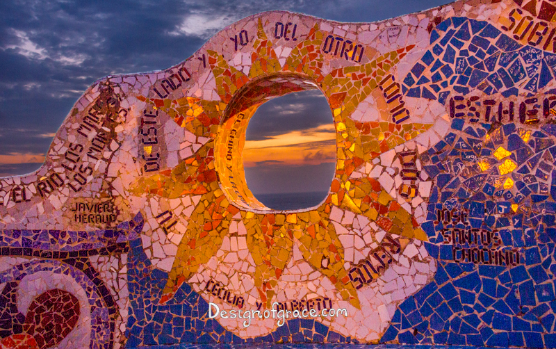 Looking through the Parque De Amor mosaic bench of a sun, Miraflores, Lima, Peru at Sunset with orange and purple hues