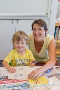 a boy and his mother posing for the camera with a dragonfly bunting on the table