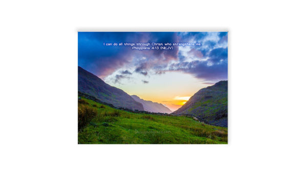 Snowdon Valley Sunset with purple and orange hues contrasted with the green grass on the bottom with 2 mountain on either side with the sun in the setted in the middle, Wales, UK with the bible inspired words "I can do all things through Christ who gives me strength .Philippians 4:13"